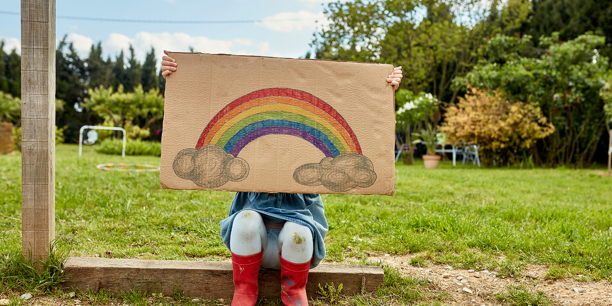 Kind mit gemaltem Regenbogen