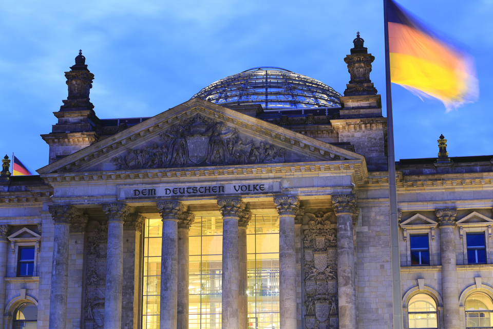 German Reichstag in Berlin at night with softly clouds and illuminated windows. Berlin, Germany.